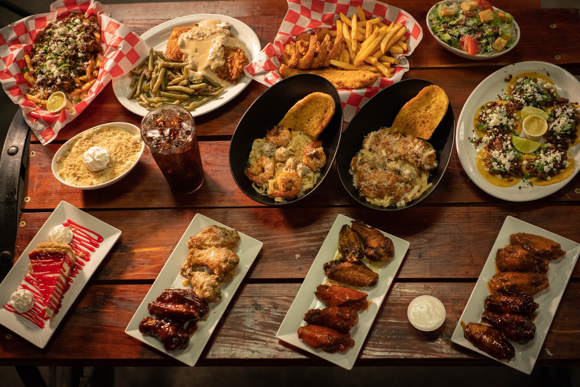 A full table spread of wings, tacos, pasta and chicken fried steak from Crawfish Getaway catering